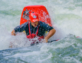 A white water kayaker riding rapids in a river